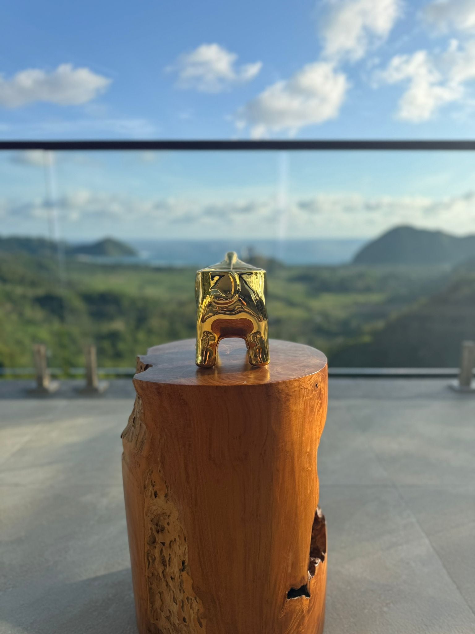 Bild 3 — Elefante Imperiale auf Holzsockel vor Landschaft, handgefertigte Goldkeramik
